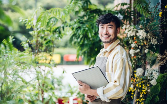 Portrait of confident young Asian male florist.